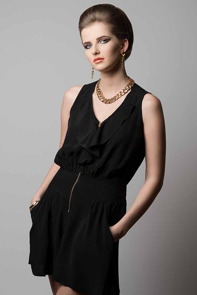 fashion shoot of young elegant girl with cute hair-style and make-up, black dress and golden jewellery
